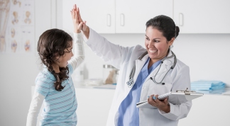 Doctor and patient high fiving in office
